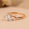 Rose gold ring with a large diamond and smaller diamonds on a beige background